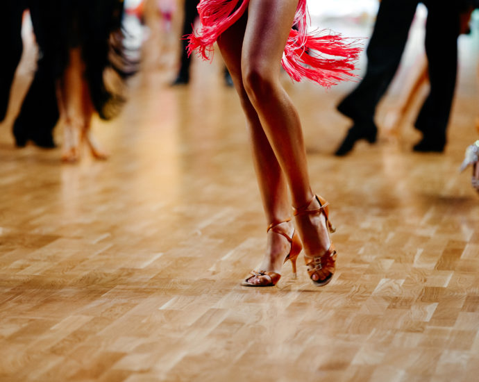 Female Latin dancer dancing alone on crowded floor