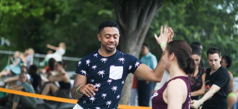 Man and woman dance Dominican bachata in park