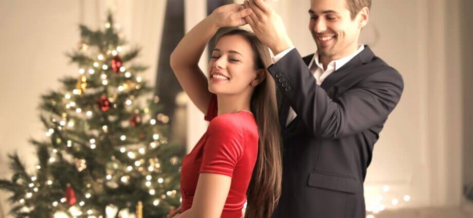 Latin dancers in front of Christmas tree and gifts